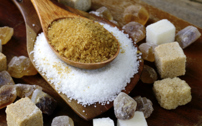 cuillère en bois avec différentes variétés de sucre : blanc, roux, cassonade et sucre cristallisé