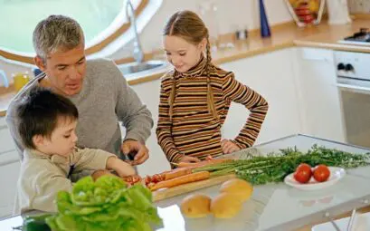 enfant participe à la préparation culinaire avec un adulte dans une cuisine