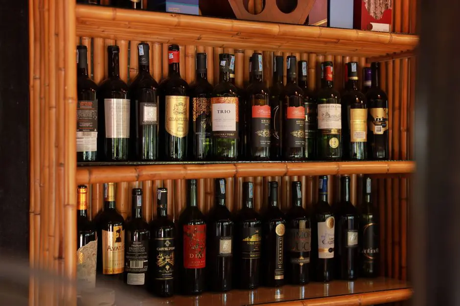 A stylish arrangement of wine bottles showcased on wooden shelves in a bar setting.